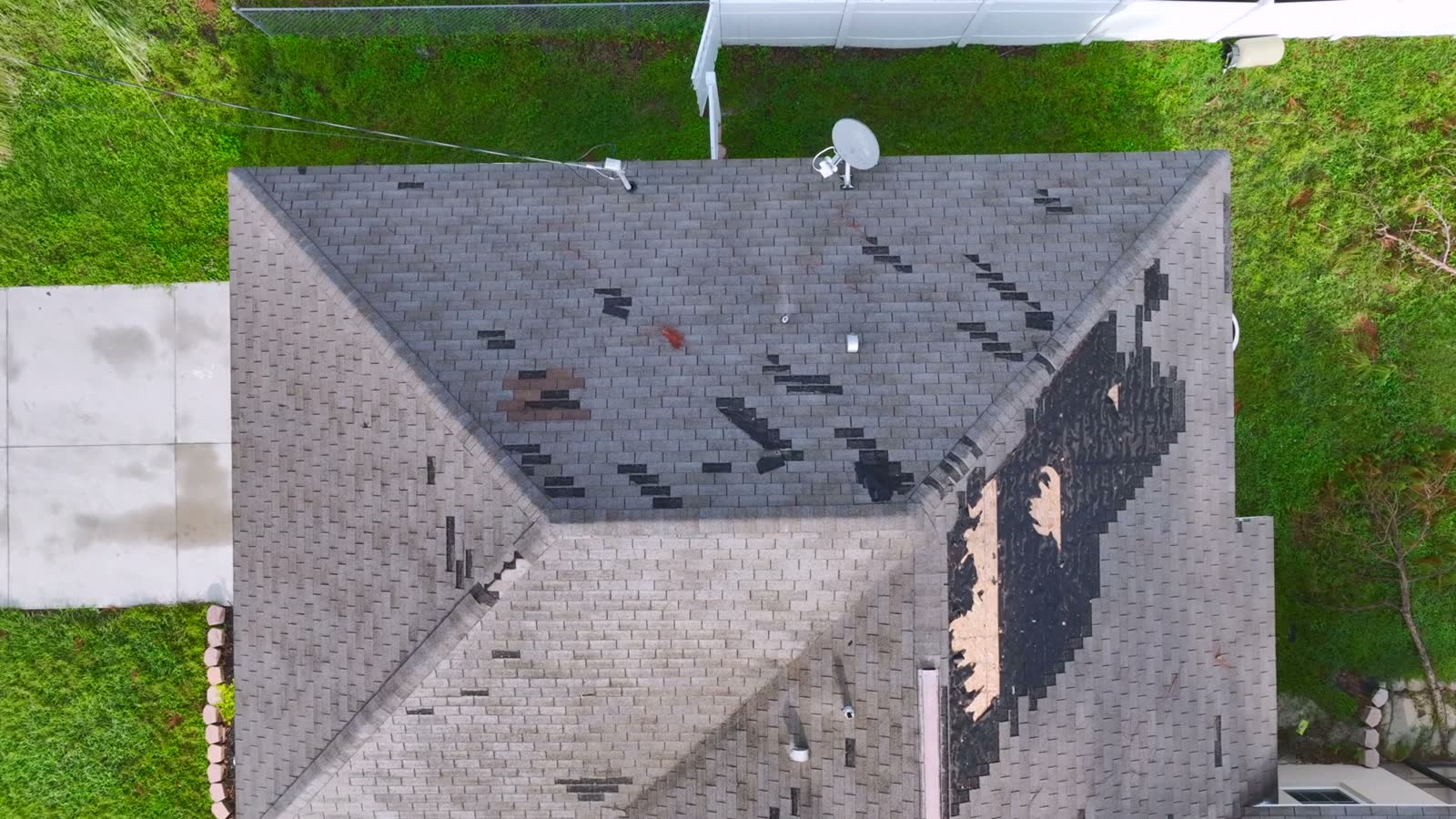 A storm-damaged roof still under a blue tarp months after the loss, the damage behind a denied Melbourne Beach, FL roof damage insurance claim