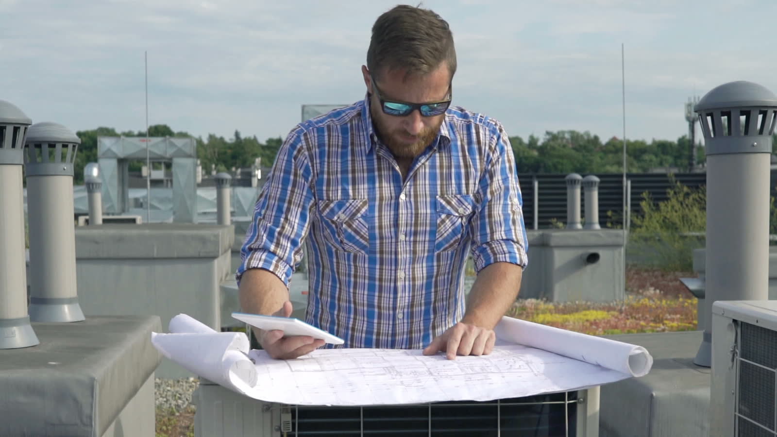 roof-damage-claim-engineer-reviews-blueprint-building-rooftop.mp4