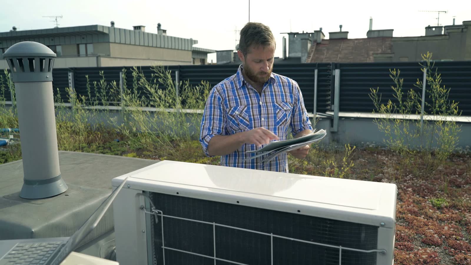 roof-damage-claim-man-inspecting-hvac-system-laptop.mp4