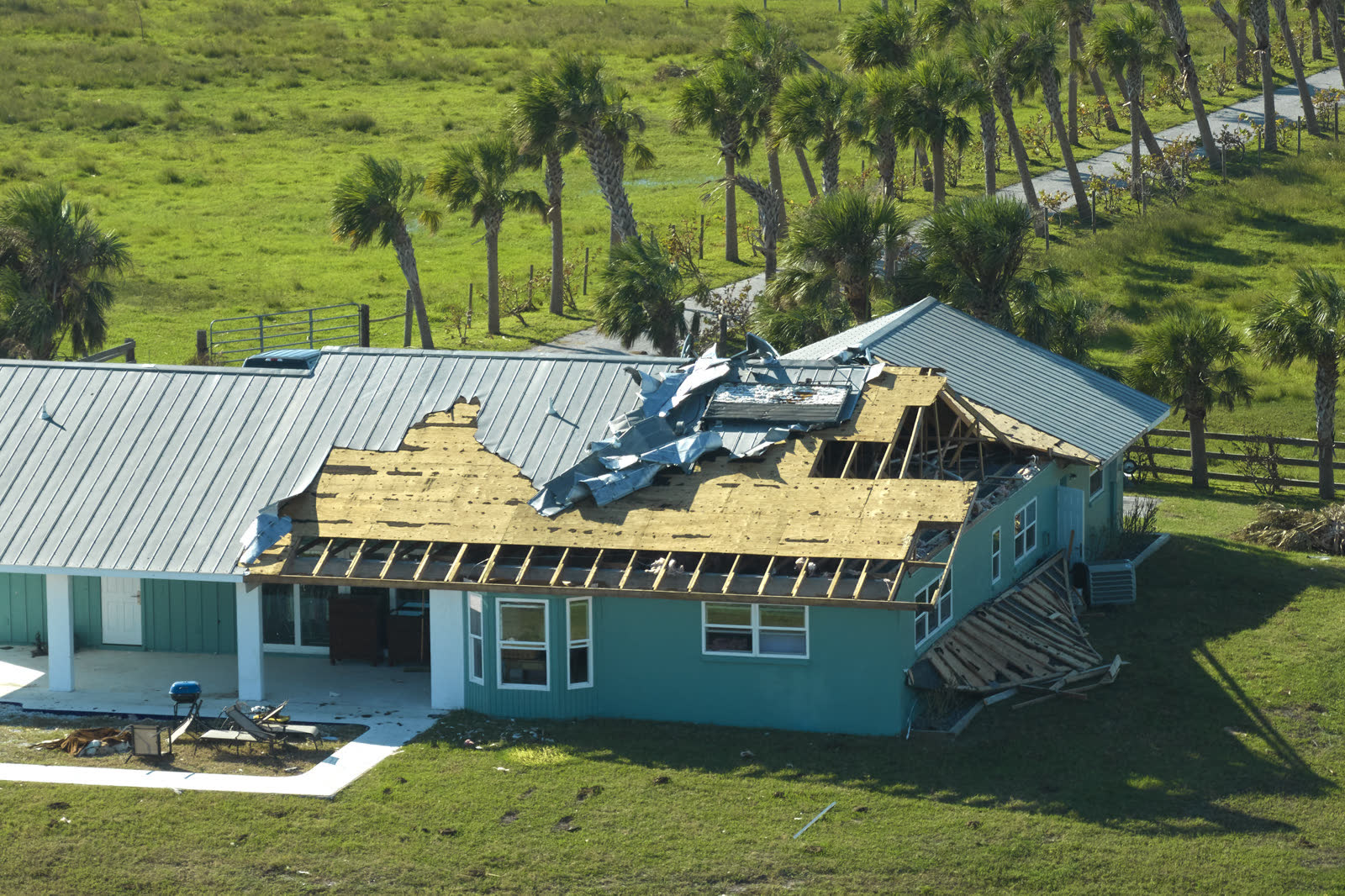 A house roof stripped of shingles by hurricane-force wind, the damage behind a denied Okeechobee, FL wind damage insurance claim