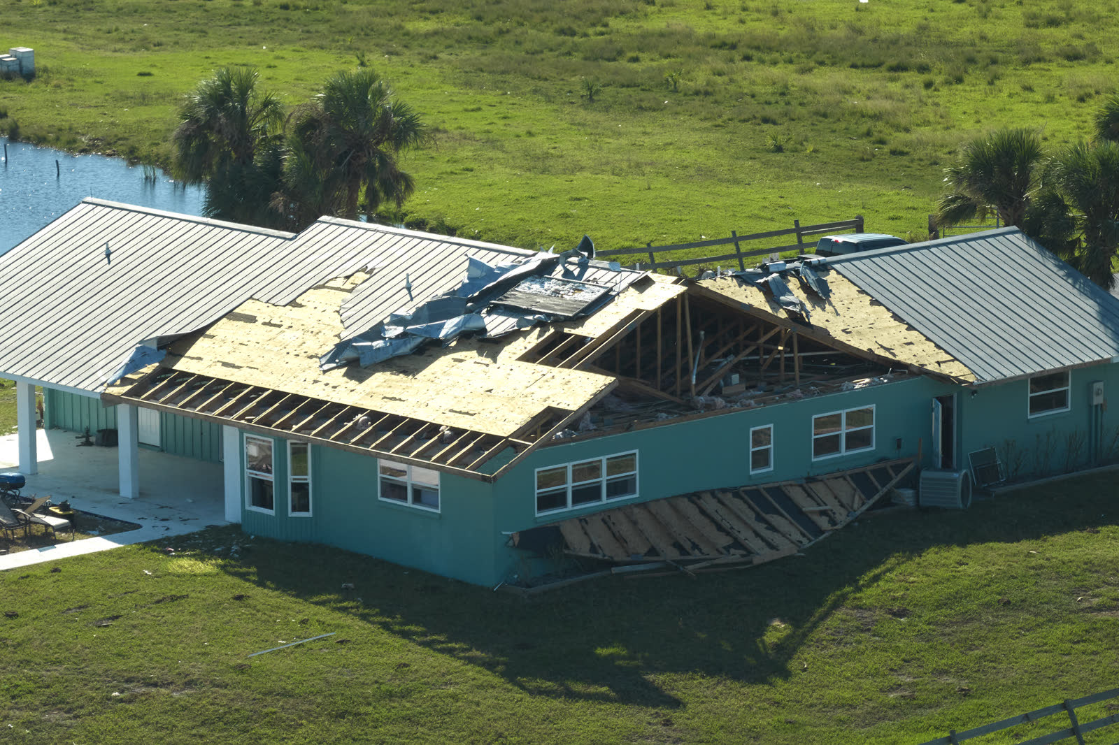 A house roof stripped of shingles by hurricane-force wind, the damage behind a denied Naples, FL wind damage insurance claim