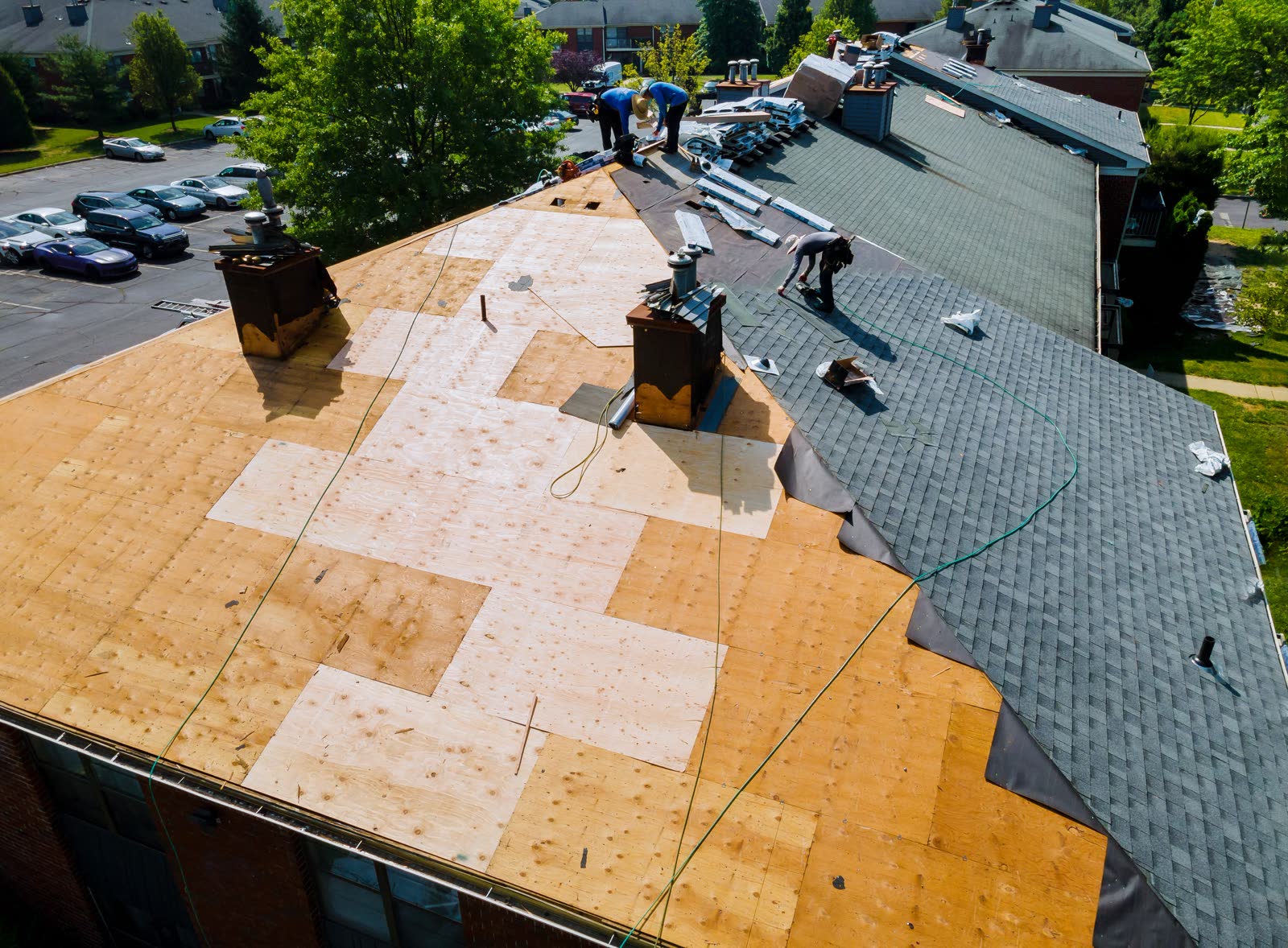 A roof mid-replacement, new shingle sections against the old field, the workmanship a homeowner is vetting a roofer for