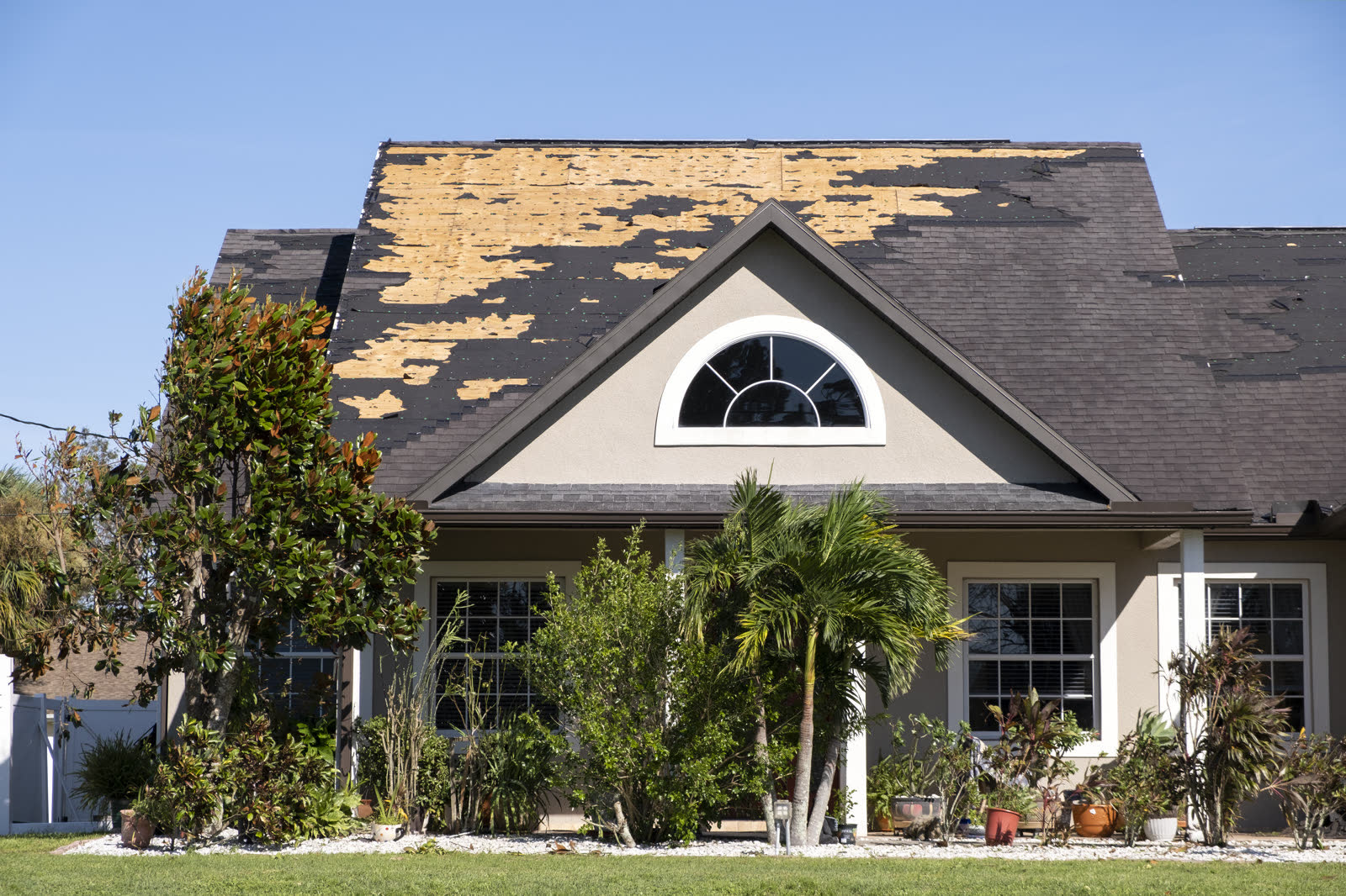 A house roof stripped of shingles by hurricane-force wind, the damage behind a denied Perry, FL wind damage insurance claim